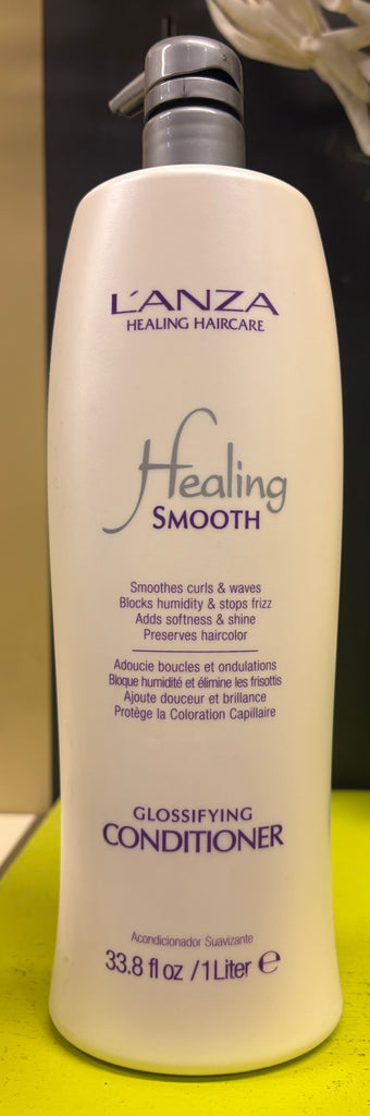 L'ANZA Healing Smooth conditioner bottle on a green surface with a blurred background